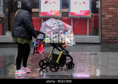 W ählende Kinderwagen mit Regenschutz in Southport, Merseyside. Januar 2019. Wetter in Großbritannien. Kalter, nasser, winterlicher, sleety, windiger Tag im Stadtzentrum. Regen und etwas Schnee breiten sich im Nordwesten aus, die Temperaturen werden voraussichtlich weiter sinken. Kredit. MWI/AlamyLiveNews/ Stockfoto