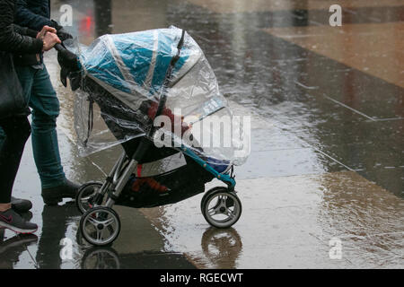 W ählende Kinderwagen mit Regenschutz in Southport, Merseyside. Januar 2019. Wetter in Großbritannien. Kalter, nasser, winterlicher, sleety, windiger Tag im Stadtzentrum. Regen und etwas Schnee breiten sich im Nordwesten aus, die Temperaturen werden voraussichtlich weiter sinken. Kredit. MWI/AlamyLiveNews/ Stockfoto