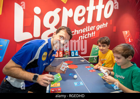 29. Januar 2019, Bayern, Nürnberg: Tischtennis Spieler Timo Boll (l) stellt Luc (r) und Hektor, das Kartenspiel Ligretto von Schmidt Spiele, während der Internationalen Spielwarenmesse Innovation zeigen. Foto: Daniel Karmann/dpa Stockfoto