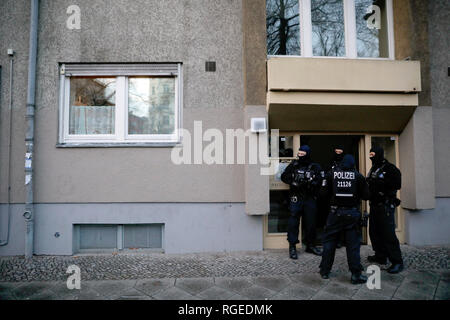 Berlin, Deutschland. 29 Jan, 2019. Polizeibeamte stehen vor einem Haus in Kreuzberg nach einem Ueberfall auf einen Geldtransporter im Oktober. Etwa drei Monate nach dem spektakulaeren Ueberfall auf einen Geldtransporter in der Nähe von Alexanderplatz, rund 180 Polizisten durchsuchten die Wohnungen von Verdächtigen. Credit: Christoph Soeder/dpa/Alamy leben Nachrichten Stockfoto