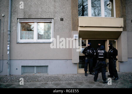 Berlin, Deutschland. 29 Jan, 2019. Polizeibeamte stehen vor einem Haus in Kreuzberg nach einem Ueberfall auf einen Geldtransporter im Oktober. Etwa drei Monate nach dem spektakulaeren Ueberfall auf einen Geldtransporter in der Nähe von Alexanderplatz, rund 180 Polizisten durchsuchten die Wohnungen von Verdächtigen. Credit: Christoph Soeder/dpa/Alamy leben Nachrichten Stockfoto