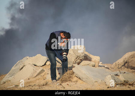 Gaza, Palästina. 29 Jan, 2019. Ein palästinensischer Journalist gesehen nach dem Einatmen von Tränengas bei Zusammenstößen zwischen Palästinensern und israelischen Streitkräfte während protestieren auf der nördlichen Gaza-Streifen betroffen. Credit: Ahmad Hasaballah/SOPA Images/ZUMA Draht/Alamy leben Nachrichten Stockfoto