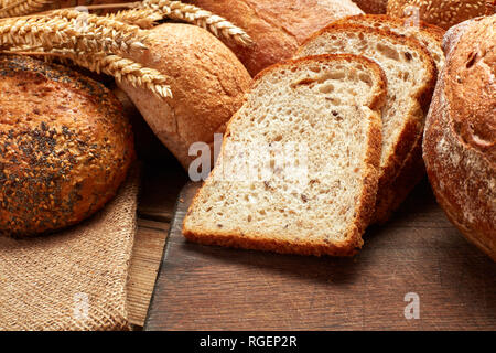 Haufen von frisch gebackenen geschnittenes Brot auf hölzernen Hintergrund Stockfoto