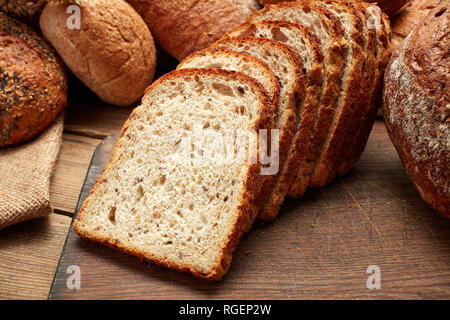 Haufen von frisch gebackenen geschnittenes Brot auf hölzernen Hintergrund Stockfoto