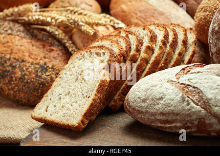 Haufen von frisch gebackenen geschnittenes Brot auf hölzernen Hintergrund Stockfoto