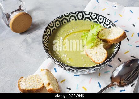 Gesunde detox Brokkoli green Creme Suppe in einer Schüssel auf konkrete Tabelle. Stockfoto