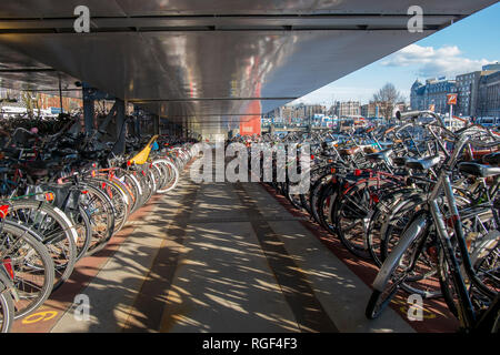 Hunderte von Fahrrädern, die in einem speziellen Parkplatz Garage für Fahrräder in der Nähe von Amsterdamer Hauptbahnhof geparkt. Stockfoto