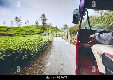 Tuk Tuk Taxi auf der Straße durch Tee Plantagen in Sri Lanka. Stockfoto