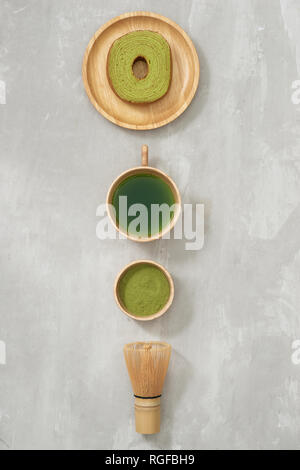 Matcha grüner Tee Latte in eine Tasse und Tee Zeremonie Utensilien mit deutschen Kuchen. Platz kopieren Stockfoto