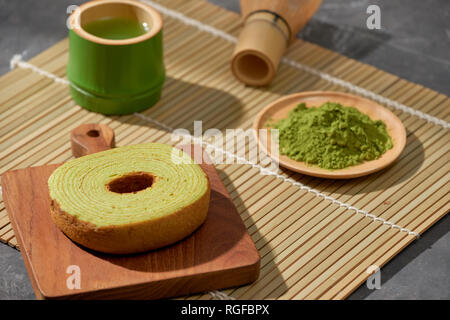Matcha grüner Tee Latte in eine Tasse und Tee Zeremonie Utensilien mit deutschen Kuchen. Platz kopieren Stockfoto