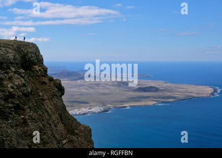 Blick vom Mirador del Bosquecillo auf einer Klippe von Risco de Famara mit Menschen. Stockfoto