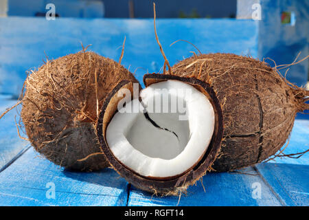 Spalter Kokosnuss auf einem blauen Hintergrund aus Holz Stockfoto