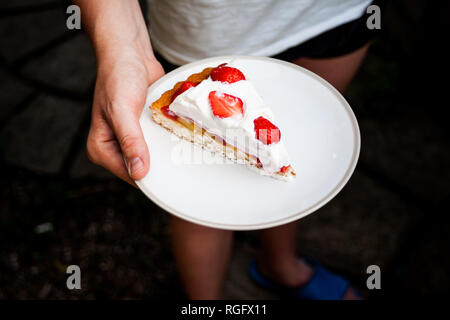 Ein Porträt des halben Körper Frau mit einem Stück Kuchen. Das köstliche Dessert mit Stolz, mit dem frischen Beeren und Sahne. Hausgemachte Süßigkeiten und de Stockfoto