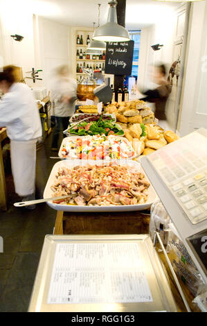 Drei Leute arbeiten hart, Zubereitung von Speisen in Fernandez und Brunnen deli London. Verschiedene Lebensmittel wie Salate zum Verkauf vorbereitet werden, sowie für das Mittagessen bereit. Stockfoto
