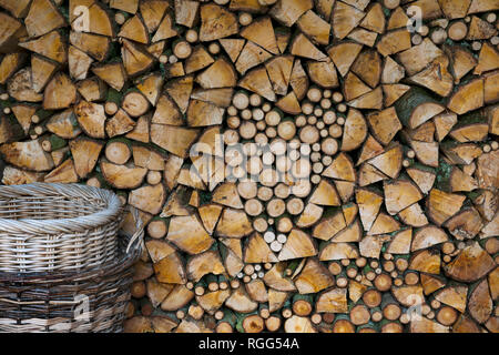 Ungewürzt brennholz Luft Trocknen im Holzschuppen. Stapel frisch geschnitten und split Feuer Holz mit Herz Form mit kontrastierenden Umläufe und Splits gebaut. Stockfoto