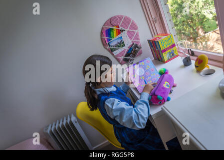 Acht Jahre alten Mädchen an ihrem Schreibtisch Stockfoto