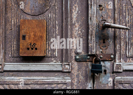 Alte Holztür mit beschädigten Farbe und Mailbox. Stockfoto