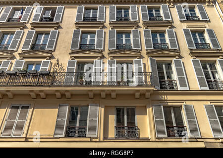 Weißen Fensterläden und schmiedeeisernen Balkon auf einer Wohnung Gebäude entlang der Rue Saint-Dominique, Paris, Frankreich Stockfoto