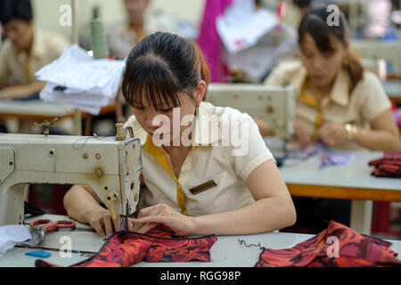 Frauen mit Nähmaschinen arbeiten bei einer Textilfabrik in Vietnam, Asien Stockfoto