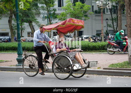 Westliche Touristen auf eine Rikscha-fahrt durch die Straßen von Hanoi, Vietnam, Asien Stockfoto