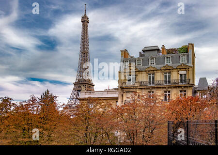 Der Eiffelturm sitzt hinter einem Grand Paris Wohnung Gebäude wie von der Avenue de Camoens mit den Bäumen drehen Ein herbstliches orange Farbe gesehen, Paris Stockfoto