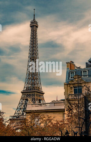 Der Eiffelturm sitzt hinter einem Grand Paris Wohnung Gebäude wie von der Avenue de Camoens mit den Bäumen drehen Ein herbstliches orange Farbe gesehen, Paris Stockfoto