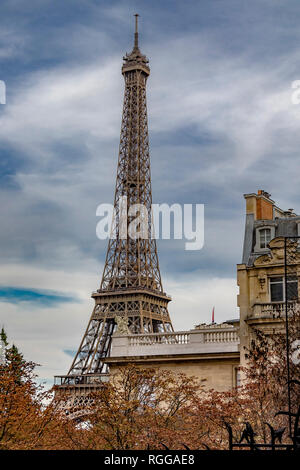 Der Eiffelturm sitzt hinter einem Grand Paris Wohnung Gebäude wie von der Avenue de Camoens mit den Bäumen drehen Ein herbstliches orange Farbe gesehen, Paris Stockfoto