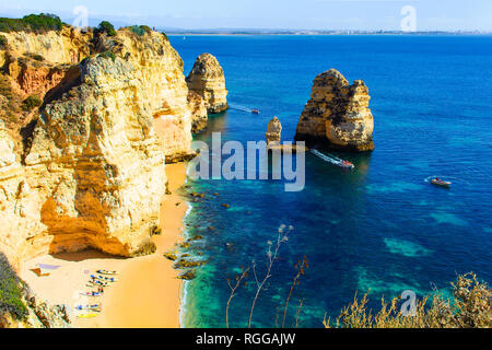 Schöne versteckte Strand zwischen Felsen und Klippen mit Kajaks und das türkisfarbene Meer in Ponta da Piedade. Region Algarve. Portugal Stockfoto