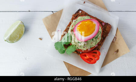 Sandwich mit violetten Rüben eingelegte Eier, Avocado und Tomaten, kopieren. Stockfoto