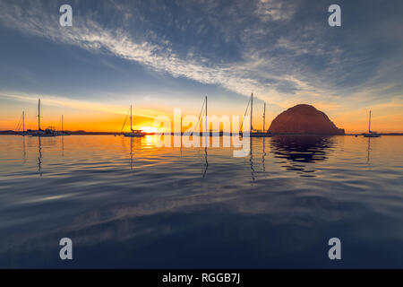 Morro Bay Harbor, Kalifornien. Schönen Sonnenuntergang mit Segelbooten und großen Morro Felsen im Meer Stockfoto