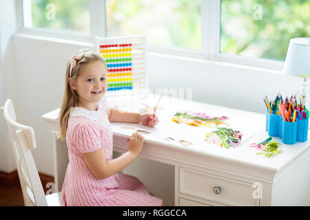 Kind Zeichnung Regenbogen. Kind malen zu Hause. Kleines Mädchen mit Hausaufgaben nach der Schule. Kinder Schreibtisch mit Abacus in Weiß sonnig Schlafzimmer. Kinder studieren, le Stockfoto