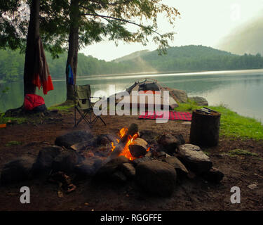 Adirondack Camping mit Lagerfeuer, Zelt Zuflucht auf einem Bergsee im Sommer. Sommer bushcraft Camping in Upstate New York. Stockfoto