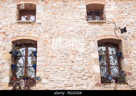 Design, Architektur und außen Konzept - schöne schmiedeeiserne Gitter im Windows auf stein Wand Stockfoto