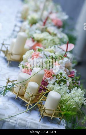 Bouquet von rosa Rosen, Holzrahmen und eine brennende Kerze in einem weißen dekorativen Vogelkäfig auf alten Board Hintergrund, Vintage Dekor und Farbe Tönung Stockfoto