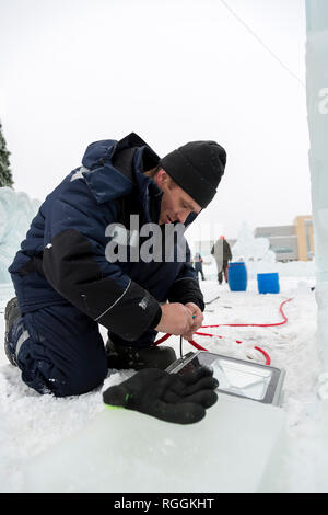 Elektriker reinigt die Enden des Kabels das Eis Figuren zu beleuchten Stockfoto