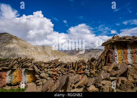 Karge Berglandschaft mit einem bunten Mani Mauer im oberen Mustang, dunkle Monsunwolken anfahren Stockfoto