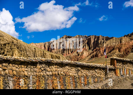 Karge Berglandschaft mit steilen Felsen und einem bunten Mani Mauer im oberen Mustang Stockfoto