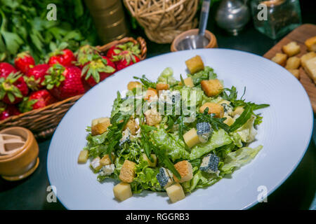 Gesunder Salat aus grünen Salat, Rucola, Scheiben frische Birnen, blaue Käse, Nüssen und Sesam Stockfoto