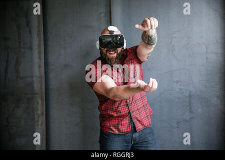 Aufgeregt, bärtigen Mann mit VR-Brille Stockfoto