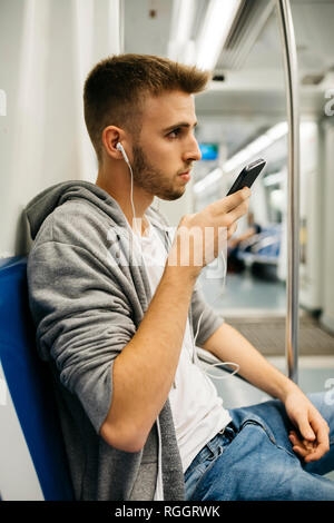 Junger Mann mit in U-Smartphone Stockfoto