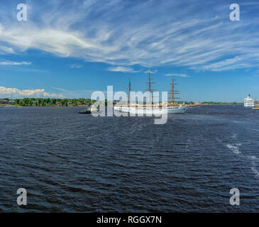 Dreimaster Segelboot Manöver auf den Fluss Daugava in Riga an einem sonnigen Sommertag mit schönen Wolken zu segeln Stockfoto