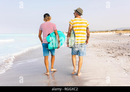 Freunde zu Fuß am Strand, Surfbretter, Rückansicht Stockfoto