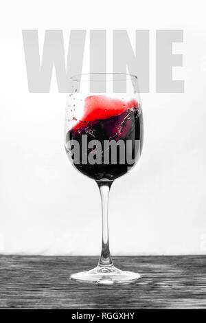 Der rote Wein im Glas spritzt in Bewegung auf einem weißen Hintergrund. Stilvolles Design drink Karte mit Text Stockfoto