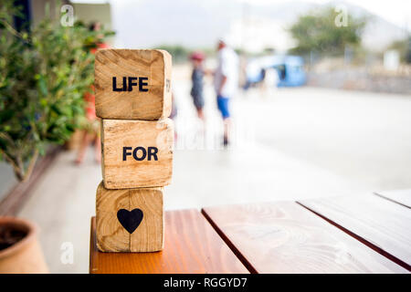 Holzblöcke mit den Worten liegen auf dem Tisch. Holzwürfel mit Buchstaben und Symbolen. Leben für die Liebe. Stockfoto