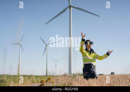 Ingenieur steht ein Feld an einem Windpark tragen VR-Brille Stockfoto
