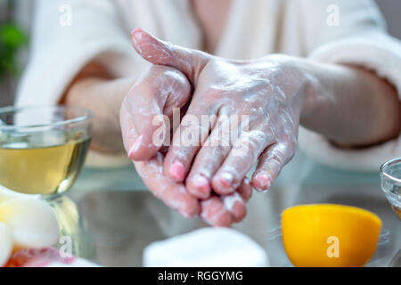 Die Frau, die Anwendung der Creme auf Ihre Hände, feuchtigkeitsspendende und nährende mit Naturkosmetik. Konzept der Hygiene und Pflege für die Haut Stockfoto