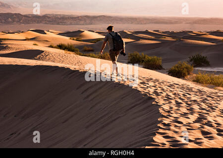 USA, Californien, Death Valley, Death Valley National Park, Mesquite flachen Sand Dünen, man walking auf Dune Stockfoto