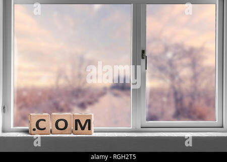 Com Zeichen in einem hellen Fenster mit Blick auf eine Straße durch eine Landschaft gehen Stockfoto
