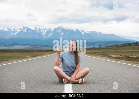 Frau sitzt auf der Straße Stockfoto