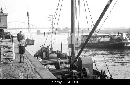 1937 Barge cargo Offloading in Arnheim. Im Hintergrund sieht man die Brücke beteiligt Operation Market Garden 1944. Der Kran wurde wiederhergestellt. Stockfoto
